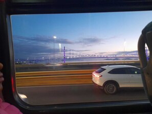 Ein Fahrzeug auf einer Straße, im Hintergrund eine Brücke.