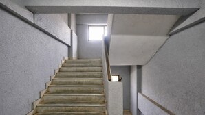 A concrete staircase with a handrail, leading to a bright area at the top. - Glitz Saineel Executive Near Juhu Beach (Mumbai)