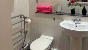 Un bagno moderno con il water, un lavandino e uno specchio.