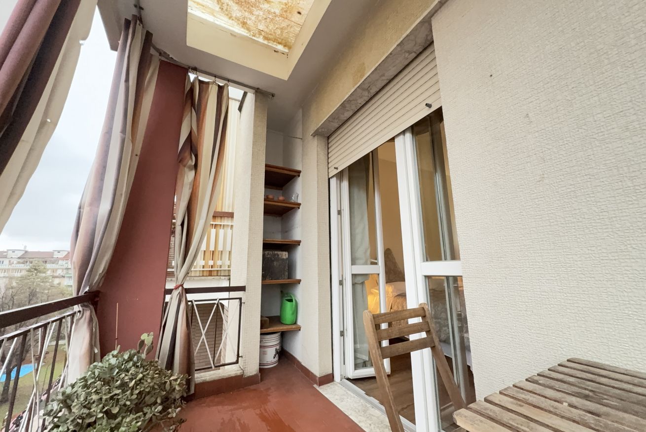 Un balcon avec vue, une porte coulissante et une chaise.