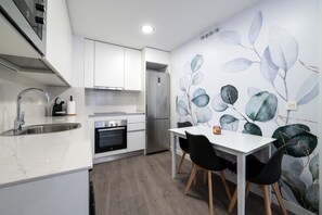A modern kitchen with white cabinetry, a built-in oven, and a stainless steel refrigerator. - Comfortable apartment for families and business travelers   (Getafe)