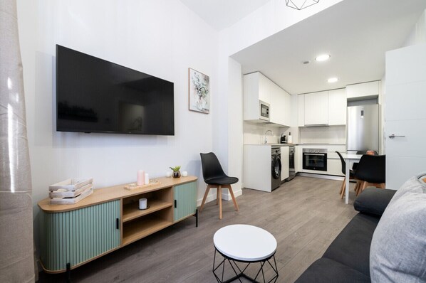 A modern apartment with a TV, kitchenette, and seating area. - Comfortable apartment for families and business travelers   (Getafe)
