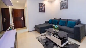 Ein modernes Wohnzimmer mit einem grauen Sofa, einem Couchtisch und zwei Bildern an der Wand.