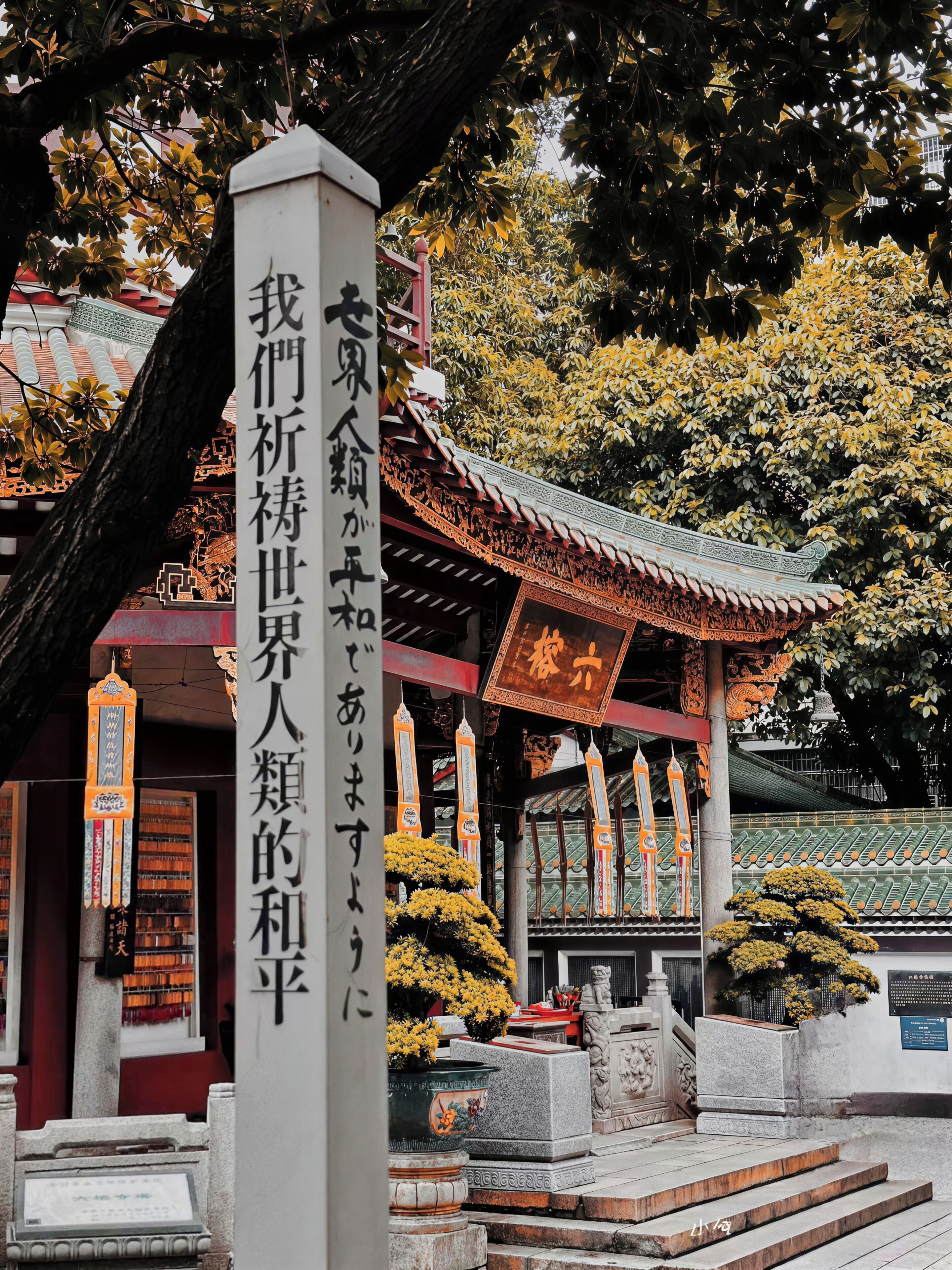 A traditional building with a prominent vertical sign, a tiled roof, and stone steps leading to the entrance.