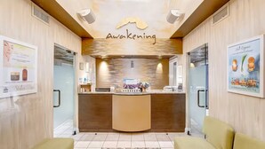 Ett välkomstområde med en skylt med texten ”Awakening”, en receptionsdisk och två gula stolar.