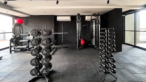 A gym with weightlifting equipment, a pull-up bar, and a red medicine ball. - Solaz by Hosppedar (João Pessoa)