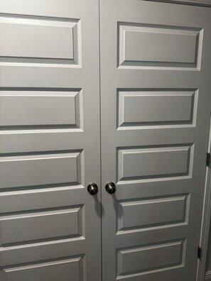Une paire de portes à double battant au design classique, dotée de panneaux rectangulaires et d’une poignée centrale.