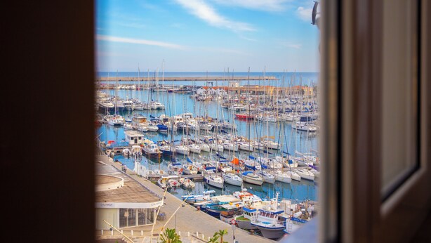 A marina with numerous boats docked, a clear sky, and a view of the sea. - Solemar Sicilia-Vista Mare Alla Cala  (Palermo)