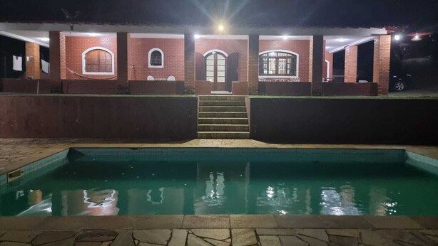 A brick building with a pool in front. - Chácara Paraíso de Itamonte (Itanhandu)