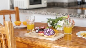 A breakfast table with pastries, juice, and a microwave in the background. - Infinity Pool Views 2 with Shared Pool, Private Terrace, and Wi-Fi (Playa de las Américas)
