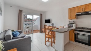 A modern apartment with a kitchen, dining area, and living room. - Infinity Pool Views 2 with Shared Pool, Private Terrace, and Wi-Fi (Playa de las Américas)