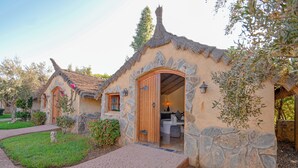 A rustic-style building with a stone facade, a thatched roof, and a wooden door. - Escale Nature near Marrakech | Private Bungalows, Pool, Terrace & Hammam (Marrakech)