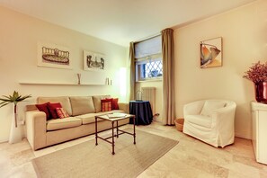 Un salon comprenant un canapé, une table basse, un fauteuil et des œuvres d ’art accrochées aux murs.