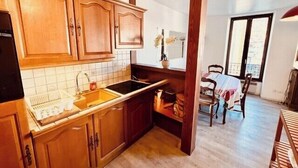 Una cucina con mobili in legno, un lavello e un'area pranzo con sedie.