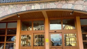 A building with a stone facade, wooden entrance, and large windows. - Bright studio in Risoul, ski on foot and comfort (Risoul)