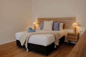 A bedroom with a bed, bedside tables, lamps, and a blanket. - Bailey Estate—Margaret River Lakeside Stay (Rosa Brook)
