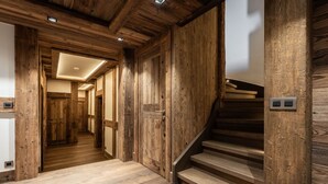 A wooden interior with a staircase and a hallway leading to another room. - Chalet Orrana in the heart of Courchevel Village (Courchevel)