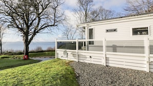 A white building with a sign reading "Pinehurst" and a view of the sea. - Argyll View Lodge (Wemyss Bay)