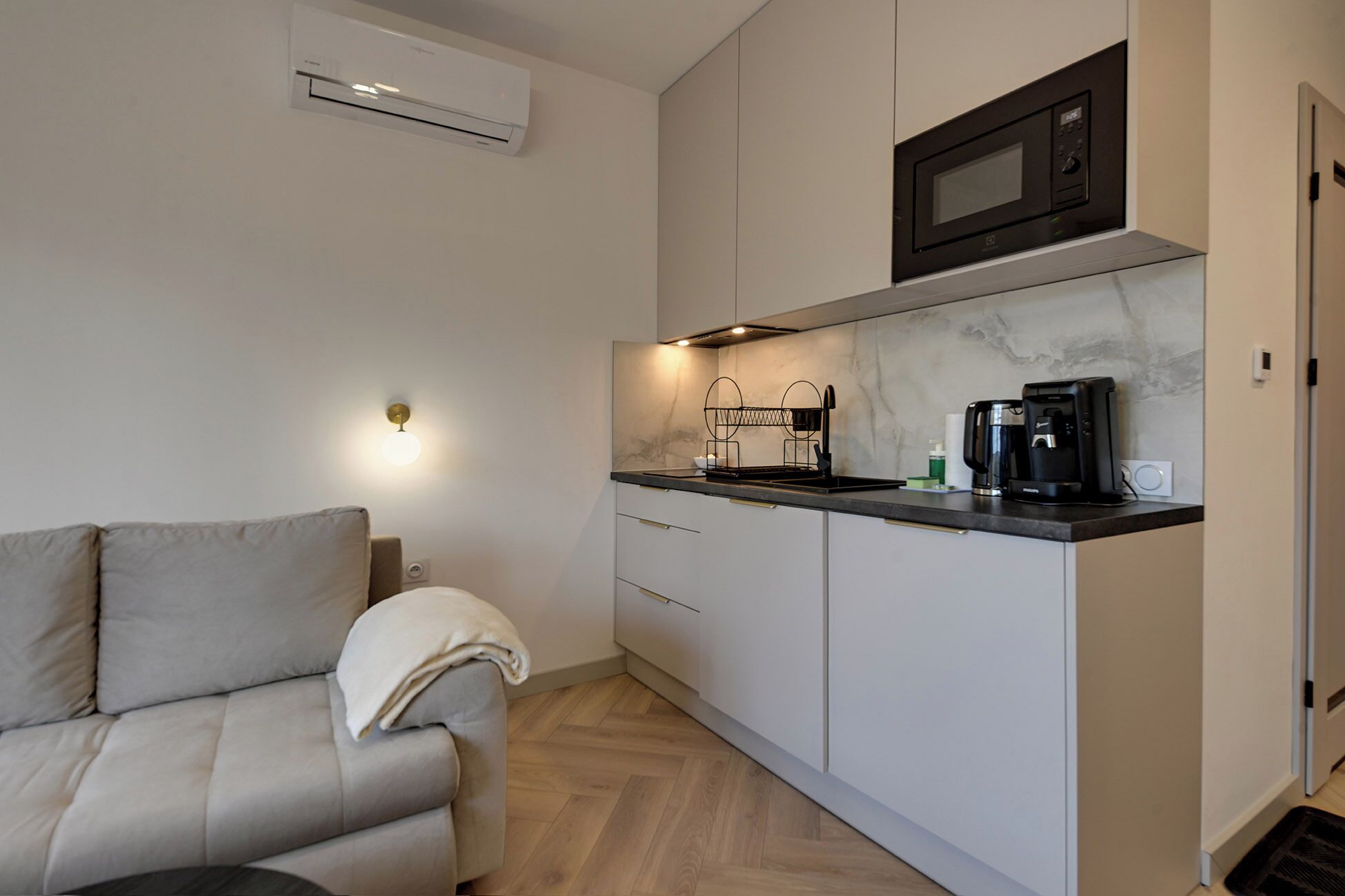 A compact kitchenette with a microwave, coffee maker, and a small sink.
