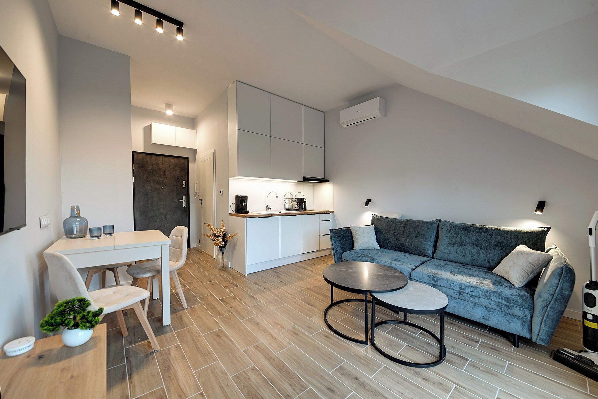 Un espacio de estar moderno con comedor, sofá y cocina.