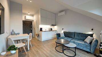 Un espacio de estar moderno con comedor, sofá y cocina.