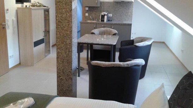 Un appartement moderne comprenant un coin repas, une cuisine et un escalier menant à un niveau supérieur.
