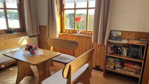 A cozy room with wooden furniture, a bookshelf, and a window with curtains. - Cozy vacation apartment on a resettlement farm (Bad Wildungen)