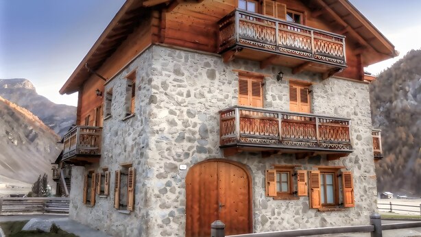 A stone building with wooden balconies and a wooden door. - Apartment '1' with Mountain View, Shared Garden and Wi-Fi (Livigno)