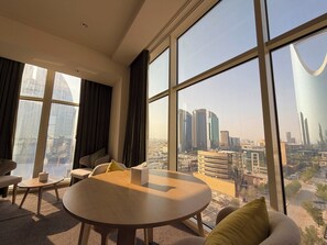 A modern hotel room with large windows offering a city view. - Sunday Hotel Al Olaya Formerly Novotel Suites Riyadh Centre (Riyadh)
