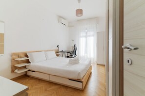A modern bedroom with a wooden bed, a desk, and a chair. - GuestHost - Elegant 45 sqm apartment located on the first floor of a building with an elevator (NOT suitable for guests with disabilities).The accommodation is located in the Navigli area, one of the most chic and sought-after districts of Milan. Its str (Milan)