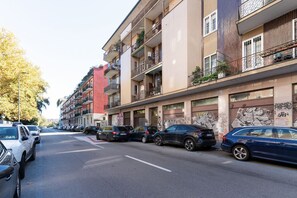 A multi-story residential building with balconies, parked cars, and graffiti on the walls. - GuestHost - Elegant 45 sqm apartment located on the first floor of a building with an elevator (NOT suitable for guests with disabilities).The accommodation is located in the Navigli area, one of the most chic and sought-after districts of Milan. Its str (Milan)