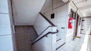A tiled stairway with a handrail, a fire extinguisher, and a barred window. - Apartamento 350m da Praia do Bessa em Joao Pessoa (João Pessoa)