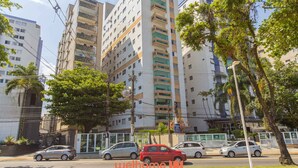 Un edificio de varios pisos con un diseño arquitectónico moderno, que cuenta con balcones y amplias ventanas.