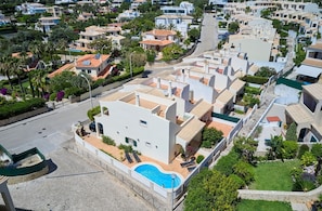 Un quartier résidentiel avec des bâtiments blancs, une piscine et une rue.
