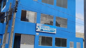 A blue building with multiple windows and a sign that reads "RECANTO CROZETO." - Private apartment with kitchen in the city center, close to everything. (Barreirinhas)