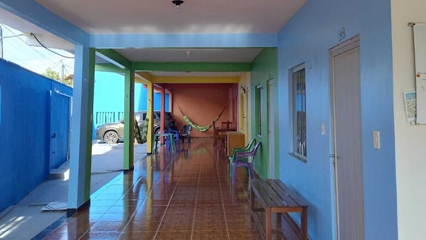 A hallway with tiled flooring, benches, and colorful walls. - Private apartment with kitchen in the city center, close to everything. (Barreirinhas)
