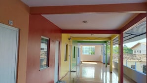 A corridor with a tiled floor, a door marked '205', and a window with a view of buildings outside. - Private apartment with kitchen in the city center, close to everything. (Barreirinhas)