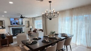 Ein geräumiges Wohnzimmer mit Essbereich, Kamin und Fernseher.