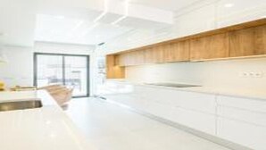 A modern kitchen with white cabinetry, a wooden countertop, and a large window providing natural light. - Villa Atlantis -Luxury 3-Bedroom Villa with Private Pool near Galé Beach (Guia)