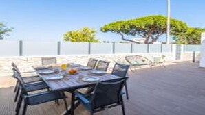 An outdoor dining area with a table set for four, surrounded by chairs, under a clear sky. - Villa Atlantis -Luxury 3-Bedroom Villa with Private Pool near Galé Beach (Guia)