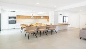 A modern kitchen with a dining area. - Villa Atlantis -Luxury 3-Bedroom Villa with Private Pool near Galé Beach (Guia)