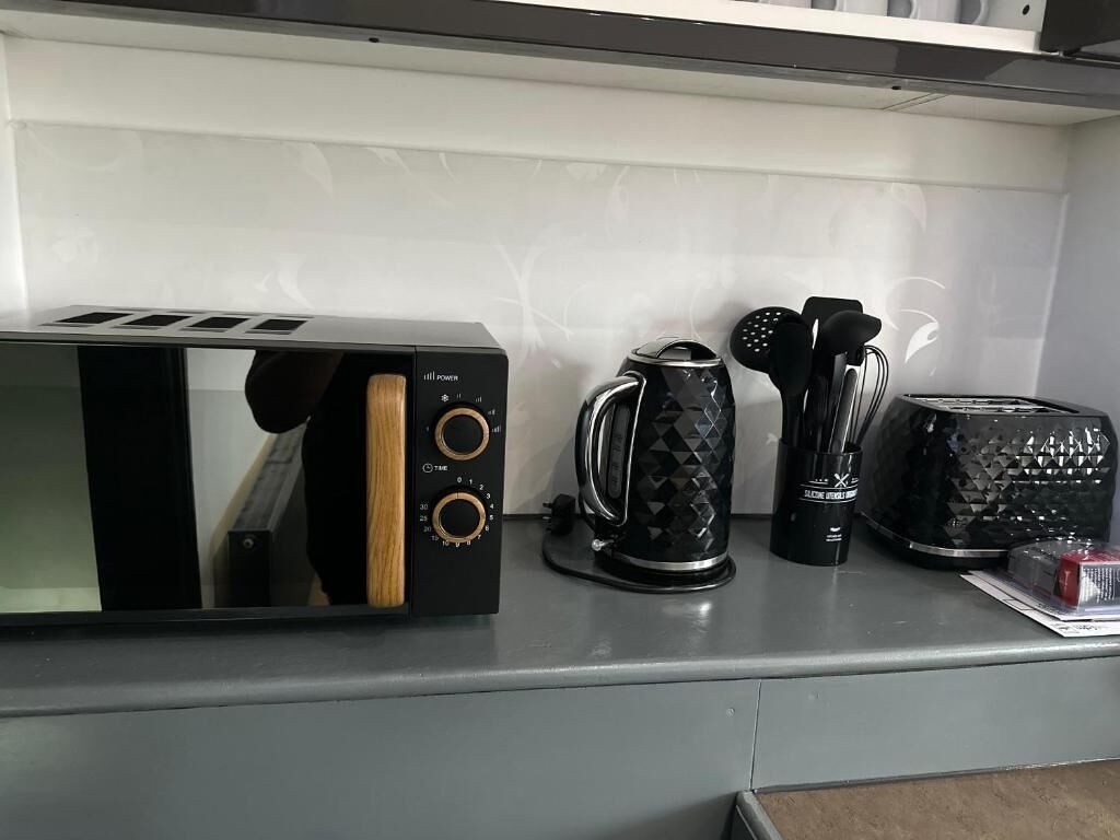 A kitchen counter with a toaster, a coffee maker, and a kettle.