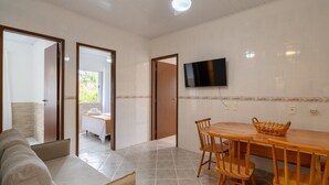 A spacious room with a dining area, a television mounted on the wall, and a view through an open door. - House w/ Barbecue 140m From the Beach Shd0071 (Florianópolis)