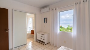 A room with a sliding door, a small white cabinet, a window with curtains, and a view of greenery outside. - House w/ Barbecue 140m From the Beach Shd0071 (Florianópolis)