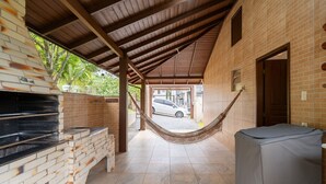 A covered outdoor area with a brick wall, a hammock, and a car parked outside. - House w/ Barbecue 140m From the Beach Shd0071 (Florianópolis)