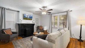 A living room with a fireplace, a sofa, a coffee table, and a lamp.