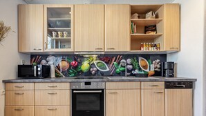A kitchen with wooden cabinets, a microwave, a coffee maker, and a dishwasher. - Apartment 'Messe-und-Ferien-Wohnung' with Wi-Fi (Seelze)