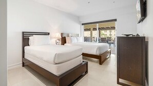 Une chambre d’hôtel avec deux lits, une télévision et une vue sur l’extérieur.