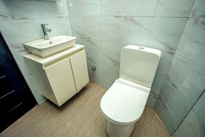 Een douche, handdoeken, zeep, toiletpapier