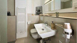 A modern bathroom with a white sink, a mirror, a towel rack, and a heater. - Central apartment in Düsseldorf: 2 beds, elevator, WiFi – Ideal for trade fairs (Düsseldorf)